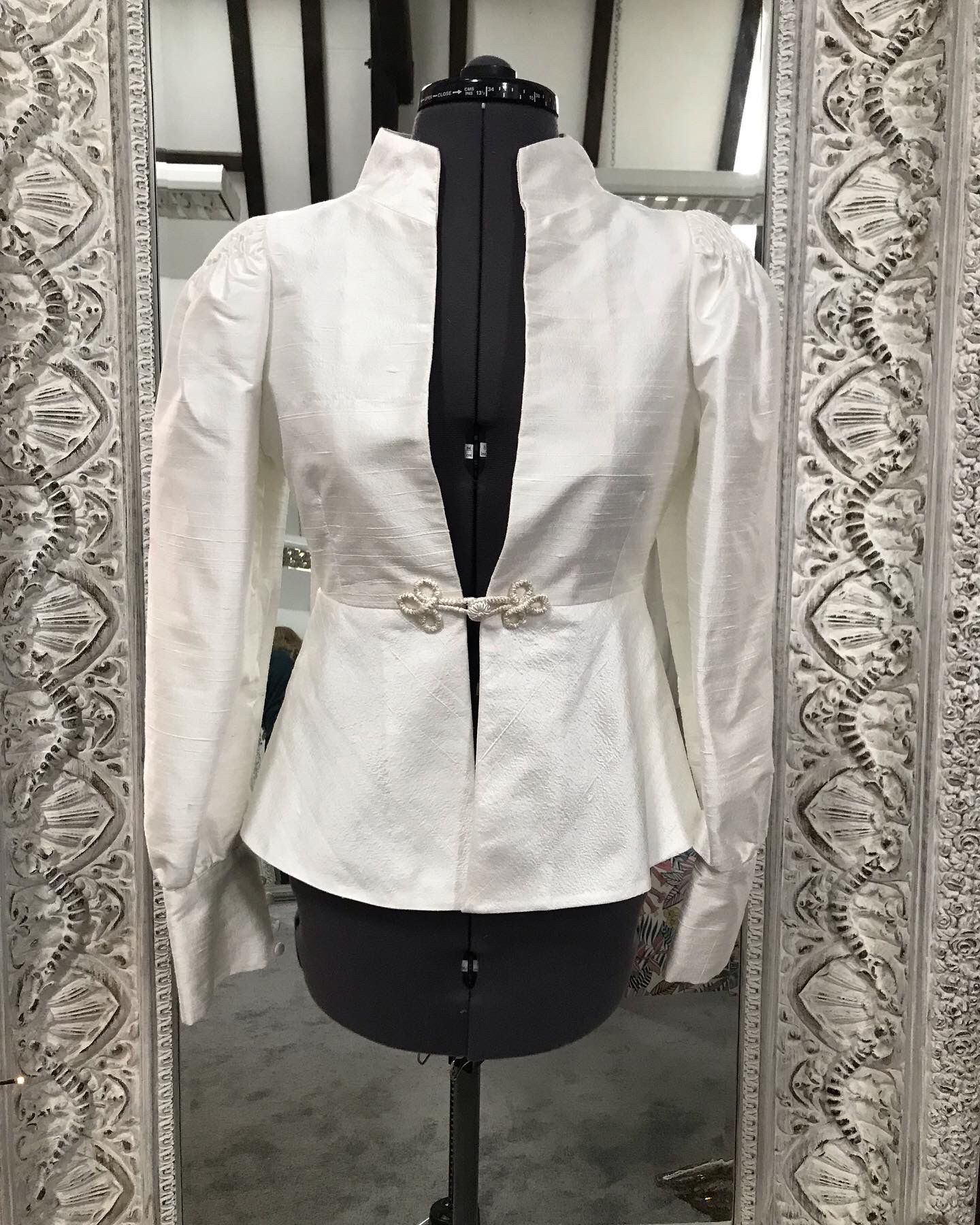 Silk bridal jacket with smocked shoulder detail for a dramatic silhouette. We added fine gold thread to the frogging closure for a subtle metallic finish.